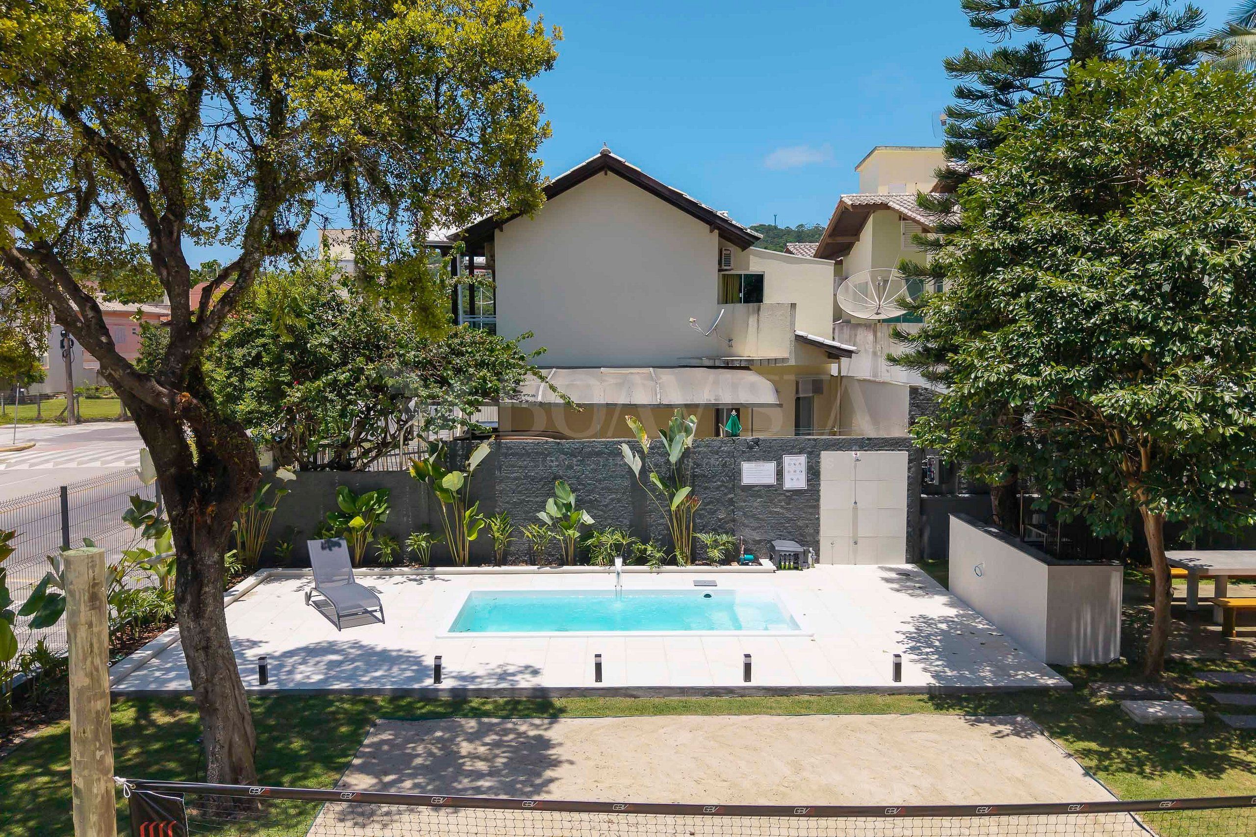 Une propriété résidentielle dotée d’une piscine, d’un patio couvert et d’un mur en pierre.