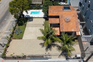 An aerial view of a building with a swimming pool, a covered patio, and a parking area. - Casa alto padrão com piscina 15 pessoas (Bombinhas)