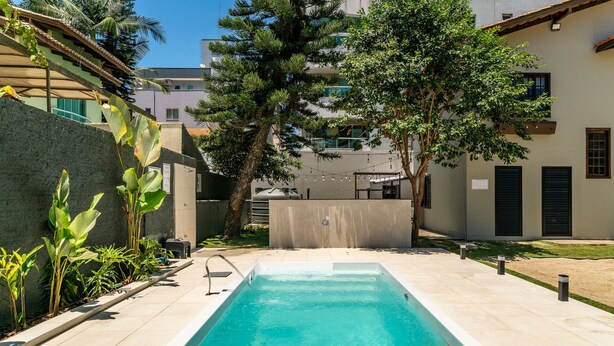 Una piscina rectangular con agua cristalina azul, rodeada por un solado de baldosas.