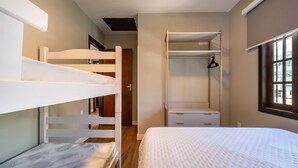 A bedroom with bunk beds, a walk-in closet, and a window with a view. - Casa alto padrão com piscina 15 pessoas (Bombinhas)