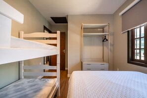 Une chambre avec des lits superposés, un dressing et une fenêtre donnant sur un beau paysage.