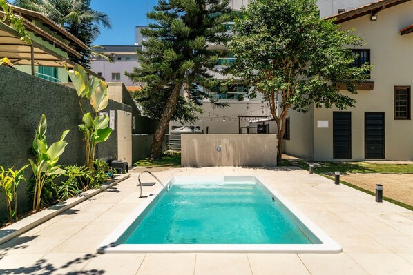 Une piscine rectangulaire à l’eau d’un bleu limpide, entourée d’une terrasse carrelée.