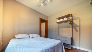 Un dormitorio con cama, armario y puerta que da a otra habitación.