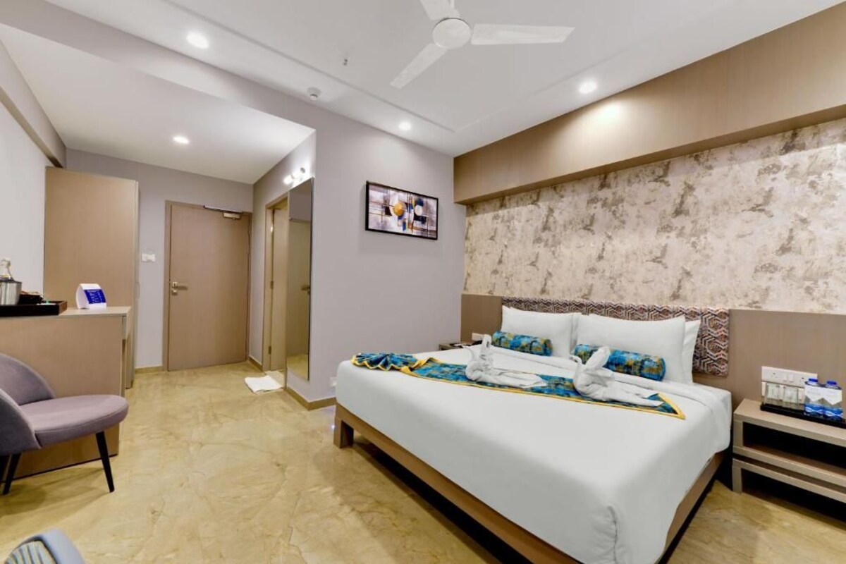 A hotel room with a bed, a desk, and a chair.