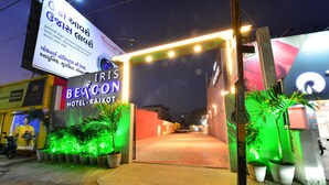 Der Eingang zum Iris Beacon Hotel mit beleuchteter Beschilderung und Pflanzkübeln.