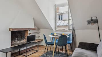 Un ambiente accogliente con camino, un tavolo da pranzo con sedie, un divano e una TV su un mobile.