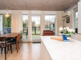 Una cocina moderna con comedor, ventanas amplias y vista al jardín.