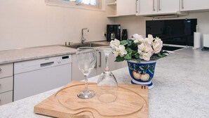 A modern kitchen with white cabinets, a wooden countertop, a sink, and a vase with flowers. - 6 Person Holiday Home in Herning (Herning)