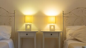 A bedroom with two single beds, each with a white headboard and a bedside table with a lamp. - Villa in Itria Valley With Infinity Pool (Cisternino)