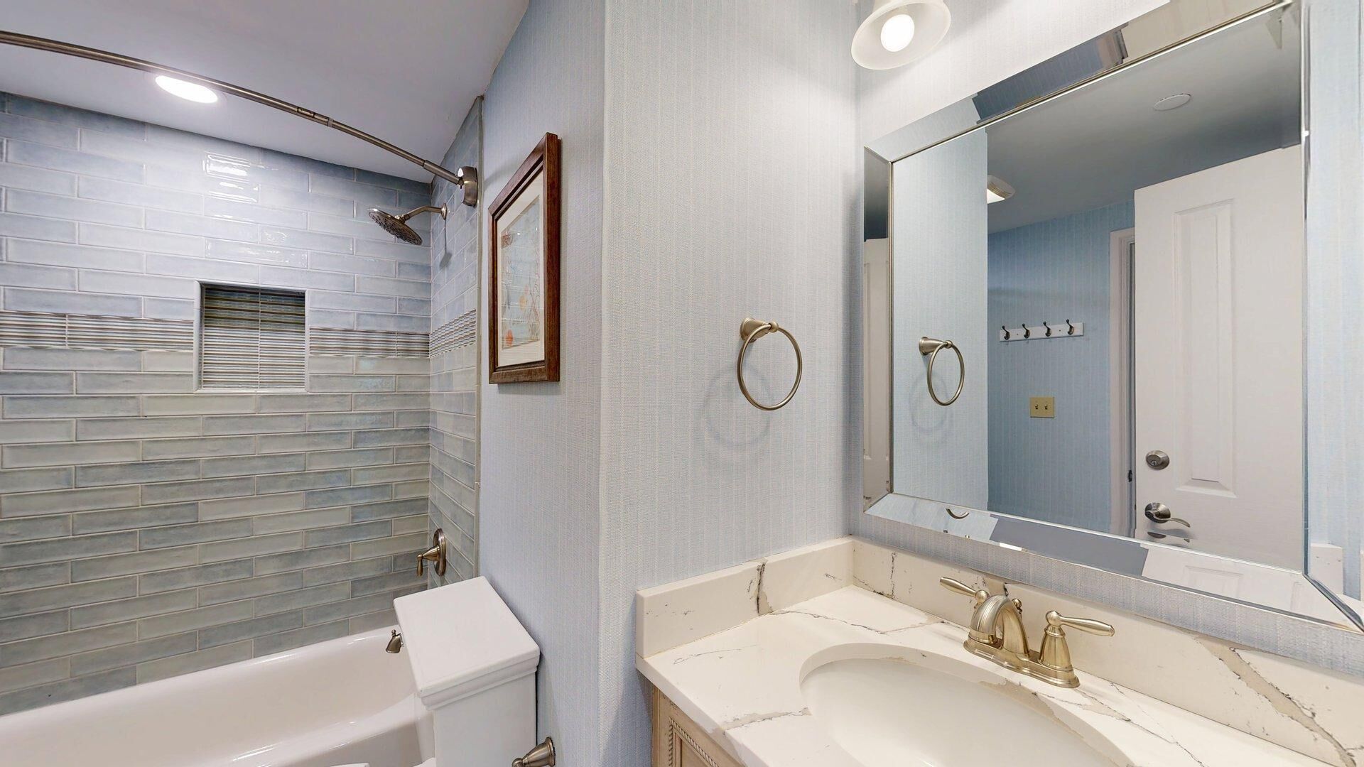 A modern bathroom with a bathtub, a sink with a large mirror, and a shower with a glass door.