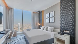 A modern hotel room with a large bed, a desk, and a view of a cityscape. - bnbme | Damac Resi (Riyadh)