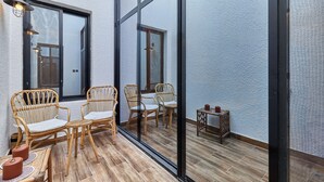 A balcony with wicker furniture, a small table, and a chair. - bnbme | Riviera-A5 | 3 Bdr (Riyadh)