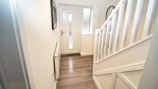 A hallway with a wooden floor, white walls, and a white door with a window. - 3 Bed, Sleeps 5, Pet Friendly, Free Parking (Mexborough)