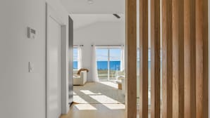 Ein modernes Interieur mit Meerblick, Holzboden und weißer Wand.