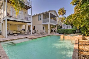 A two-story house with a swimming pool, outdoor furniture, and a covered patio area. - Holmes Beach Family Home: Private Pool & 3 Decks! (Holmes Beach)