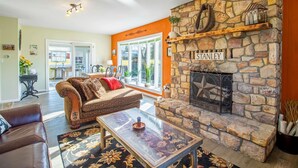 A living room with a stone fireplace, a sofa, and a coffee table.