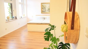 Une chambre à coucher avec un lit, une fenêtre, un tableau et une décoration murale en bois.