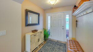 A hallway with a white door, a mirror, a light fixture, a bench, and a cabinet. - ~ 3 Mi to Ski & Hiking Trails: Soldotna Home (Soldotna)