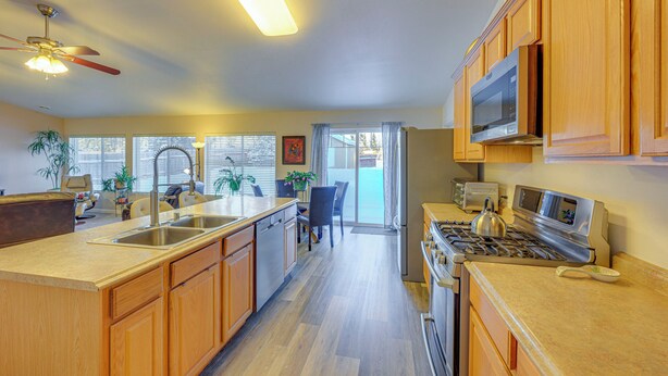 A kitchen with wooden cabinets, a stainless steel stove, and a microwave. - ~ 3 Mi to Ski & Hiking Trails: Soldotna Home (Soldotna)