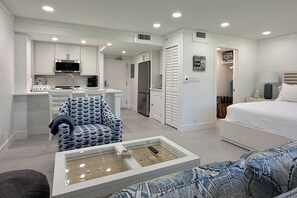 A compact living space with a kitchenette, a dining area, a bedroom, and a seating area with a glass-top coffee table. - Sanibel Island Studio: Pool Access, Walk to Beach (Sanibel)