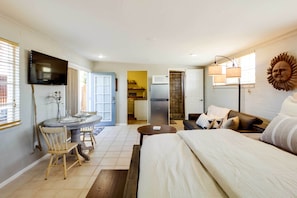 A compact living space with a dining area, kitchenette, and a bed. - Adorable Tucson Studio w/ Gas Grill & Wifi! (Tucson)