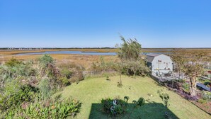 A grassy yard with a barn, a small pond, and a fence. - Walk to Beach: Duplex in North Topsail Beach! (Sneads Ferry)