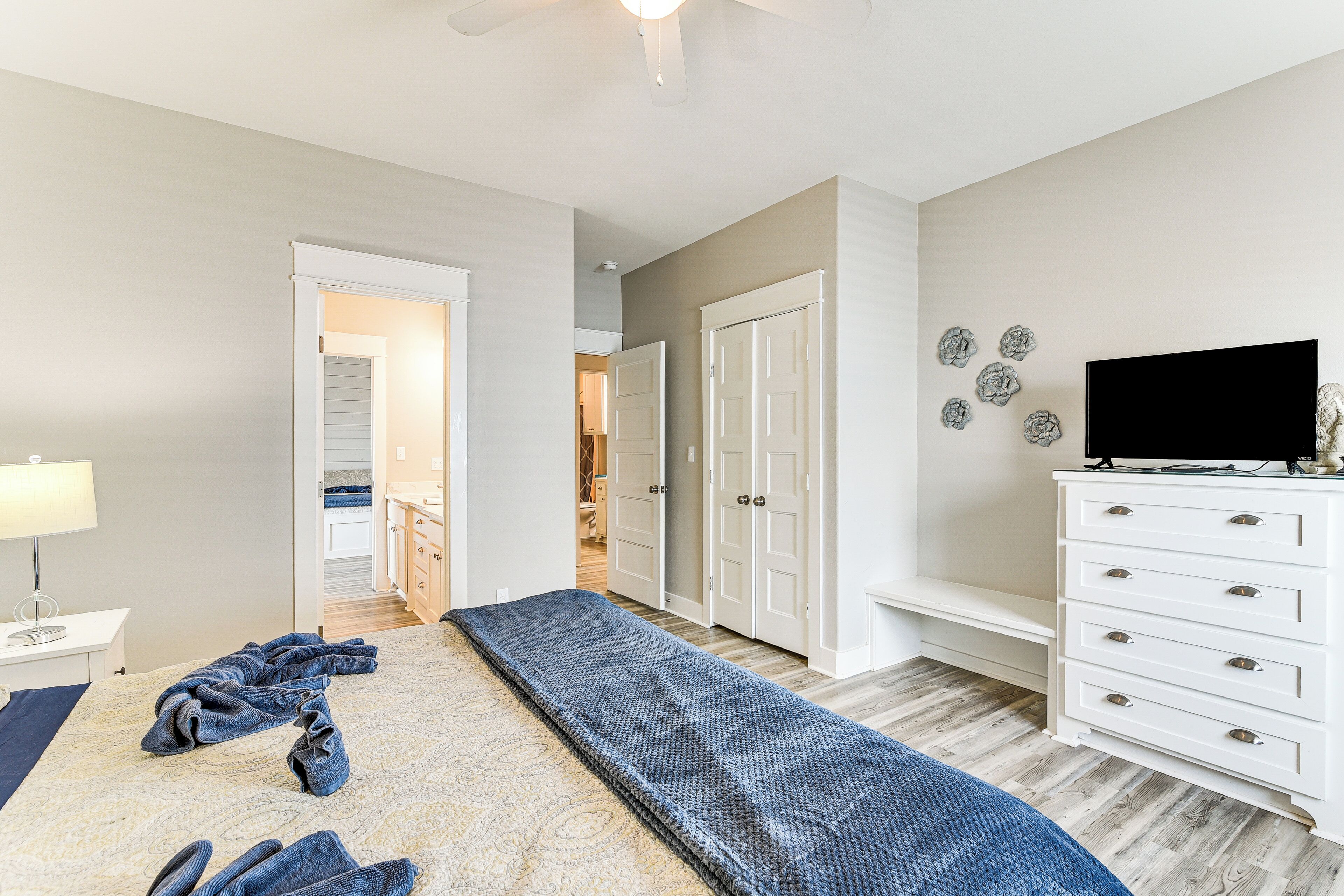 Une chambre à coucher comprenant un lit, un banc, une commode et un téléviseur.