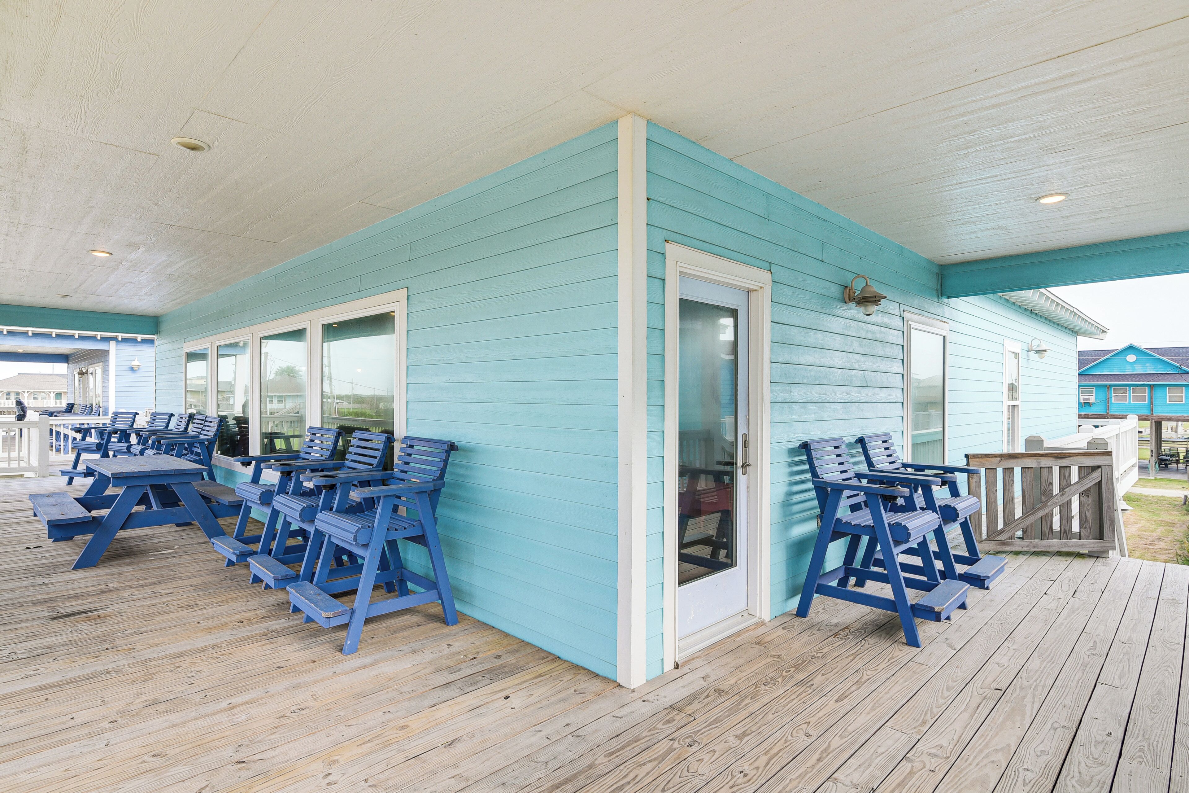 A covered outdoor area with blue benches and picnic tables.