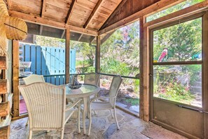 A covered patio with wicker furniture and a view of a garden. - Rustic-yet-cozy Cabin w/ Patio, 12 Mi to Asheville (Arden)