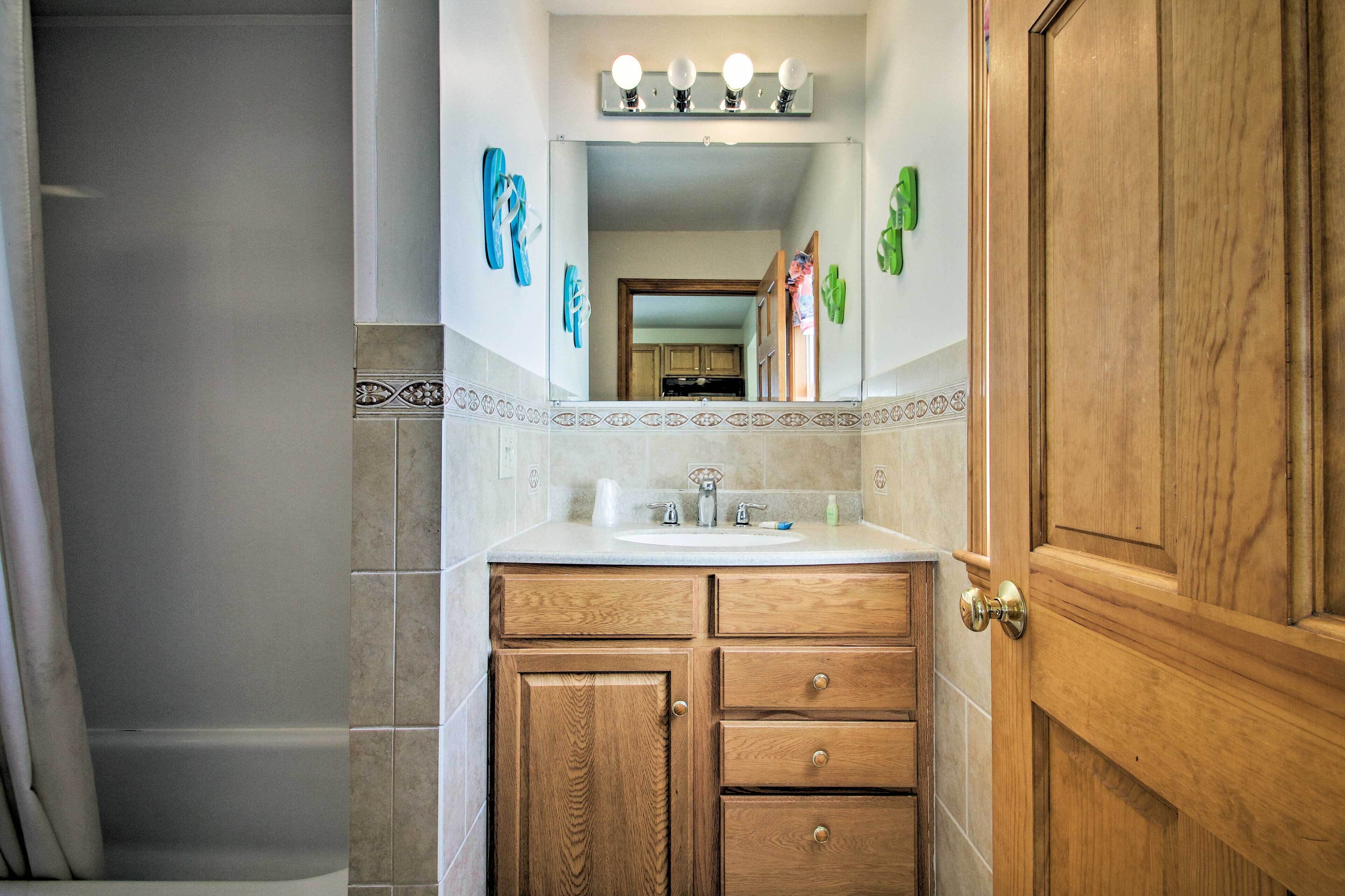 Une salle de bain avec un meuble-lavabo en bois, un évier et un miroir.