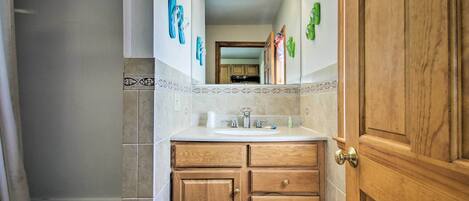 Une salle de bain avec un meuble-lavabo en bois, un évier et un miroir.