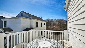 A white deck with a round table and two chairs, overlooking a residential area. - Old Orchard Beach Apt - Walk to Beach & Pier! (Old Orchard Beach)