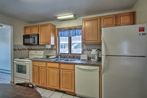 A kitchen with wooden cabinets, a microwave, stove, dishwasher, and a refrigerator. - Old Orchard Beach Apt - Walk to Beach & Pier! (Old Orchard Beach)