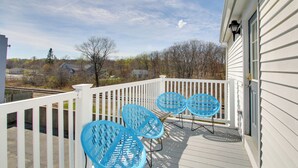 A wooden deck with a white railing, three blue chairs, and a view of houses and trees in the background. - Apt in Old Orchard Beach - Walk to Bay + Pier (Old Orchard Beach)