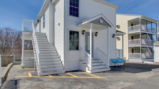 A white two-story building with a front porch, a staircase, and a balcony. - Apt in Old Orchard Beach - Walk to Bay + Pier (Old Orchard Beach)