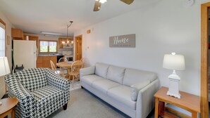 A cozy living room with a sofa, a houndstooth patterned chair, a wooden coffee table, and a lamp. - Apt in Old Orchard Beach - Walk to Bay + Pier (Old Orchard Beach)