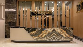 Una recepción con encimera de mármol y un letrero que dice "DEDEMAN ADANA".