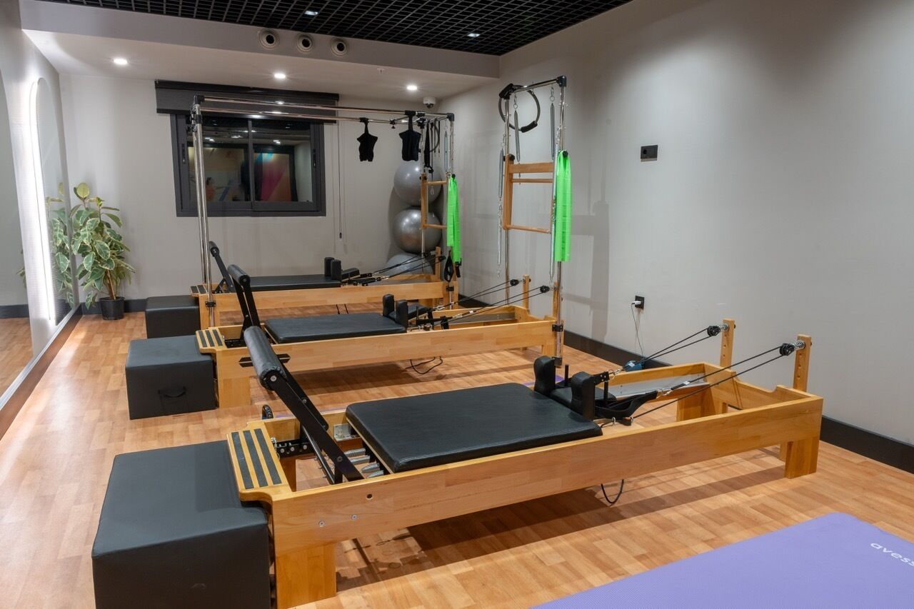 Un studio de Pilates équipé de matériel, d’un grand miroir et de ballons d’exercice.