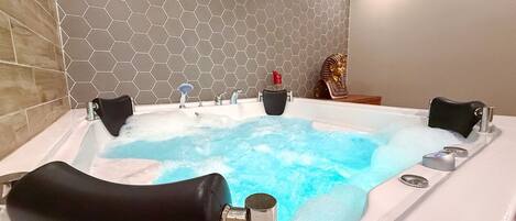 Un baño moderno con una bañera grande, ducha e inodoro.