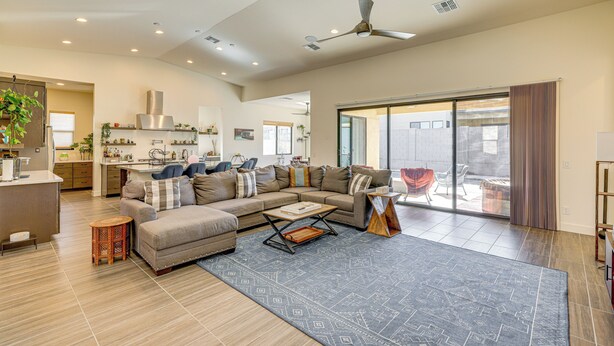 A spacious living area with a large sofa, a coffee table, and a kitchen in the background. - Mtn Views, Pool & Hot Tub: Phoenix Oasis (Phoenix)