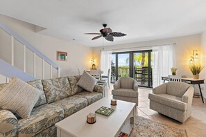 A modern living room with a sofa, armchairs, a coffee table, and a ceiling fan. - Waterfront Matlacha Condo w/ Patio & Pool Access (Matlacha)