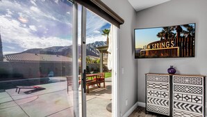 A room with a sliding glass door leading to a patio with a pool, outdoor furniture, and a view of mountains. - Near Downtown: Palm Springs Home w/ Mountain Views (Palm Springs)