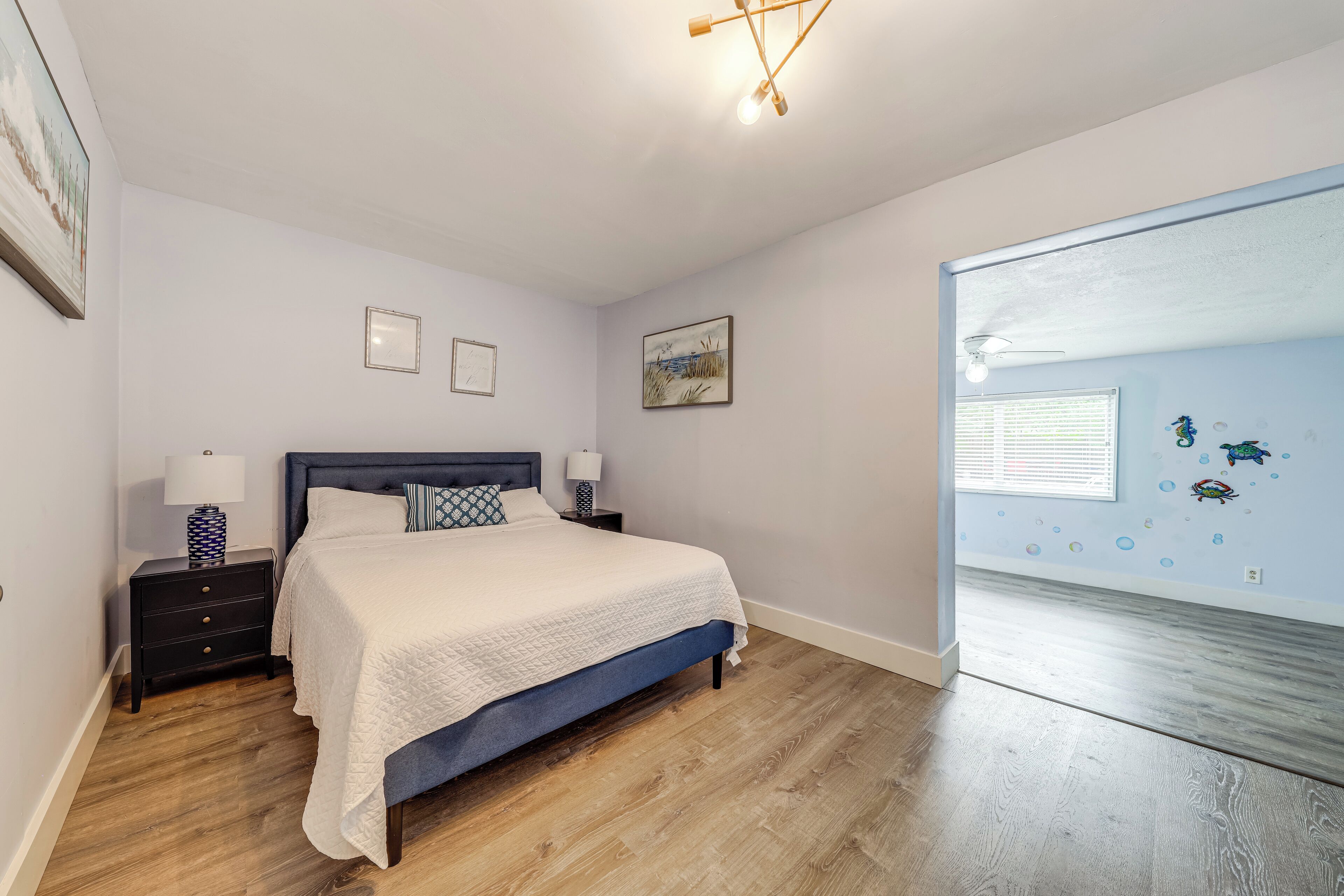 A bedroom with a bed, nightstands, and a window with a view.