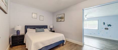 A bedroom with a bed, nightstands, and a window with a view.