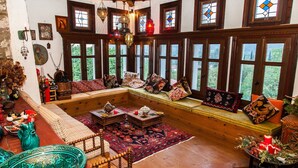 Una stanza accogliente e ben illuminata, con mobili in legno, ampie finestre e diversi oggetti decorativi.