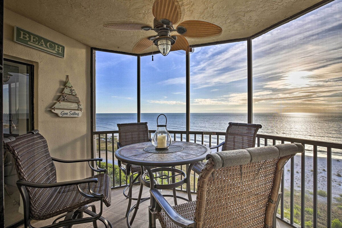 Ein Balkon mit Korbmöbeln, einem Deckenventilator und Blick auf das Meer.