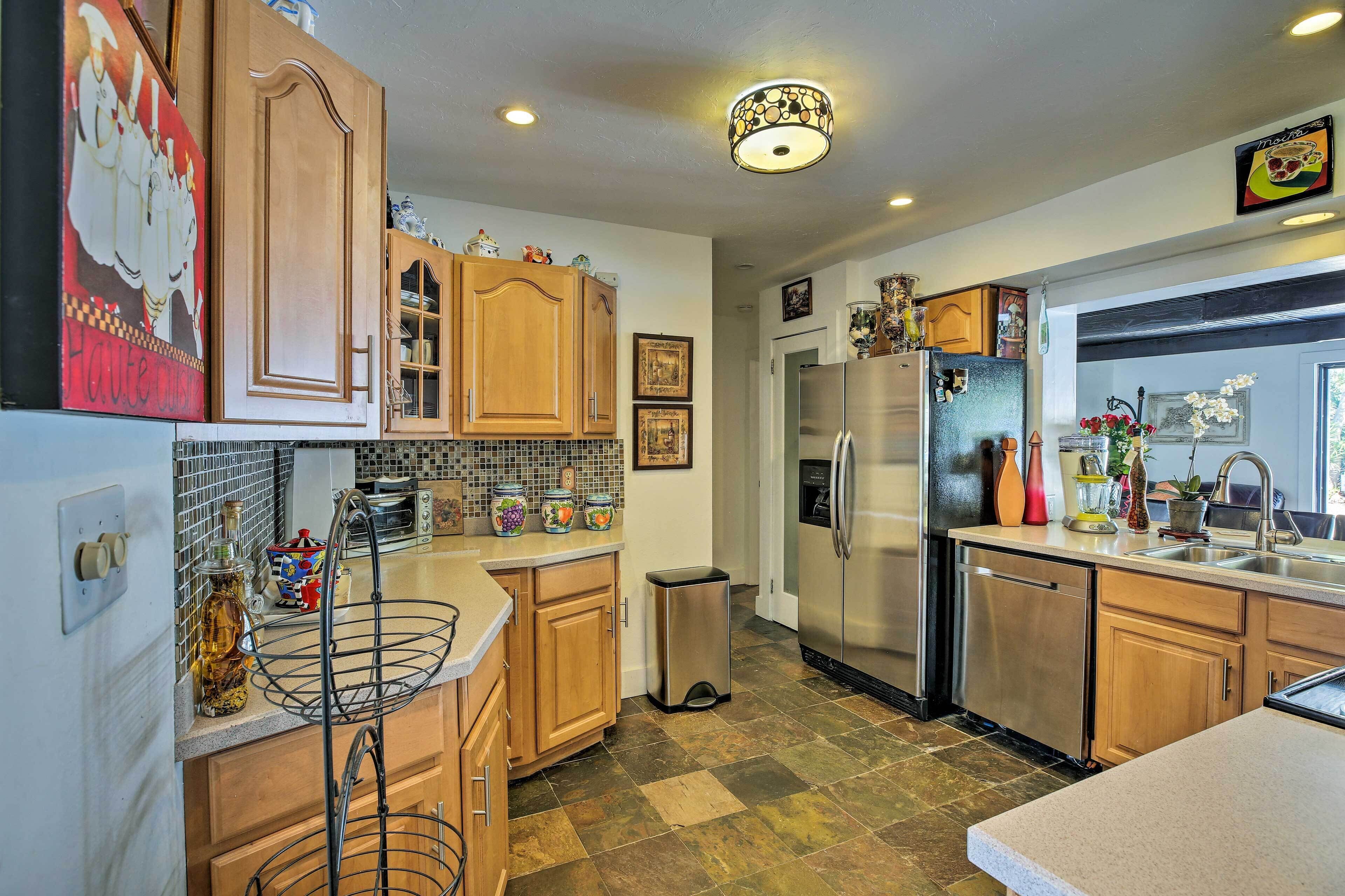 Una cocina con armarios de madera, un refrigerador de acero inoxidable y salpicadero de azulejos.
