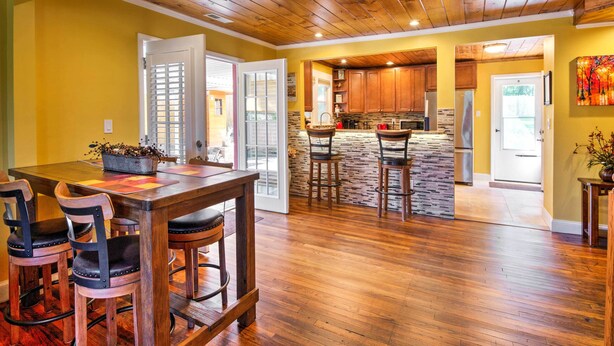A spacious kitchen with wooden cabinets, a stone backsplash, and a built-in refrigerator. - Lovely Cottage w/ Sauna & Fire Pit Near Asheville! (Swannanoa)