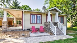 A house with a covered porch, two red Adirondack chairs, a stone staircase, and a brick pathway. - Lovely Cottage w/ Sauna & Fire Pit Near Asheville! (Swannanoa)