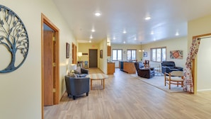 A spacious living area with a wooden floor, a sofa, a chair, and a dining table. - Spacious Home 10 Minutes to Ten Sleep Canyon! (Ten Sleep)